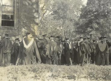 black and white photo of a 1928 academic procession (from behind, showing students&amp;#039; backs)