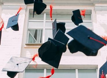 Graduation caps being tossed into air